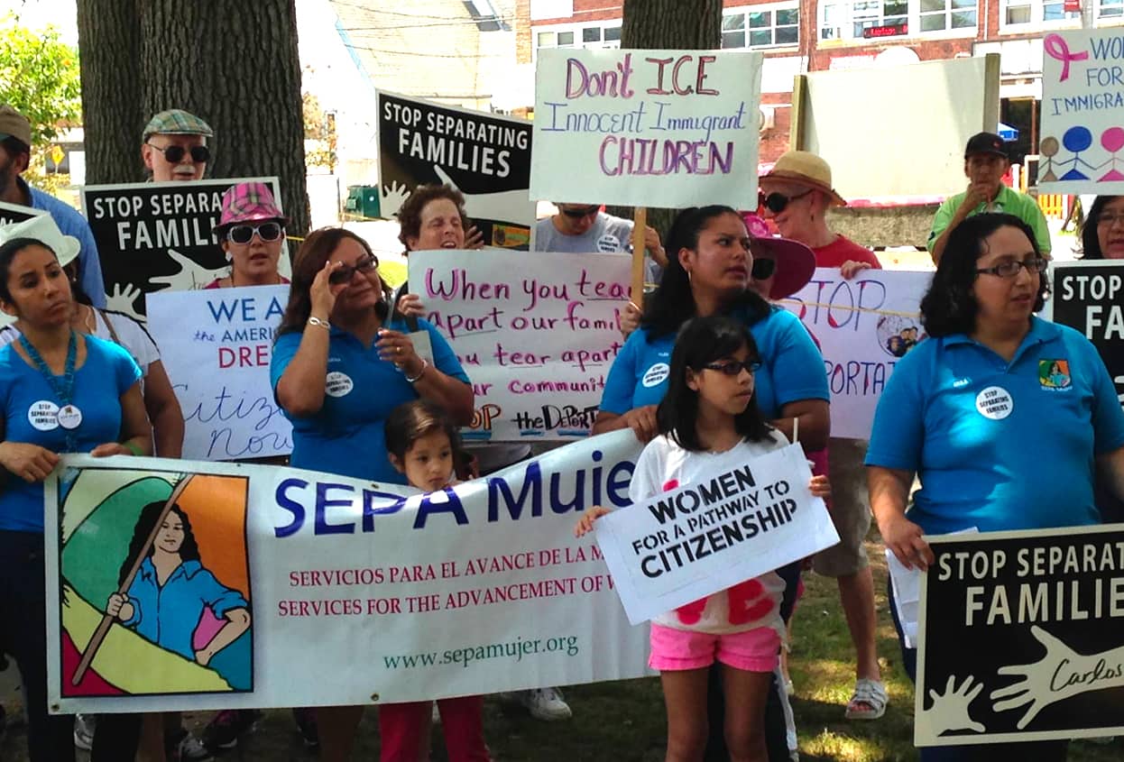 A group of people hold protest signs outside